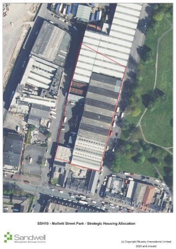An aerial view of a large industrial or warehouse complex with multiple long, rectangular buildings, bordered by streets at the bottom and a green park area to the right. A red boundary line encloses a section of the buildings.