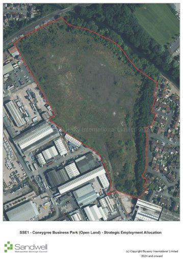 Aerial view of Conyngreave Business Park area outlined with a red boundary line, showing industrial buildings to the south, residential houses to the east, and a large green open land area with trees at the top and right side.